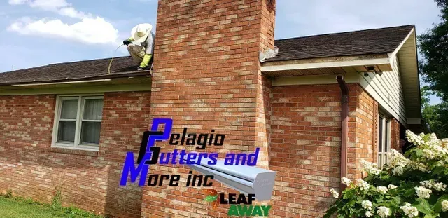 A worker on a roof near a brick chimney installs a gutter. Company logo in the bottom left.