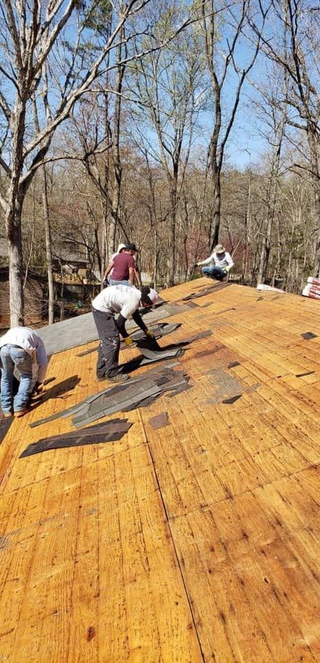 Roofers working on a house roof on a sunny day.