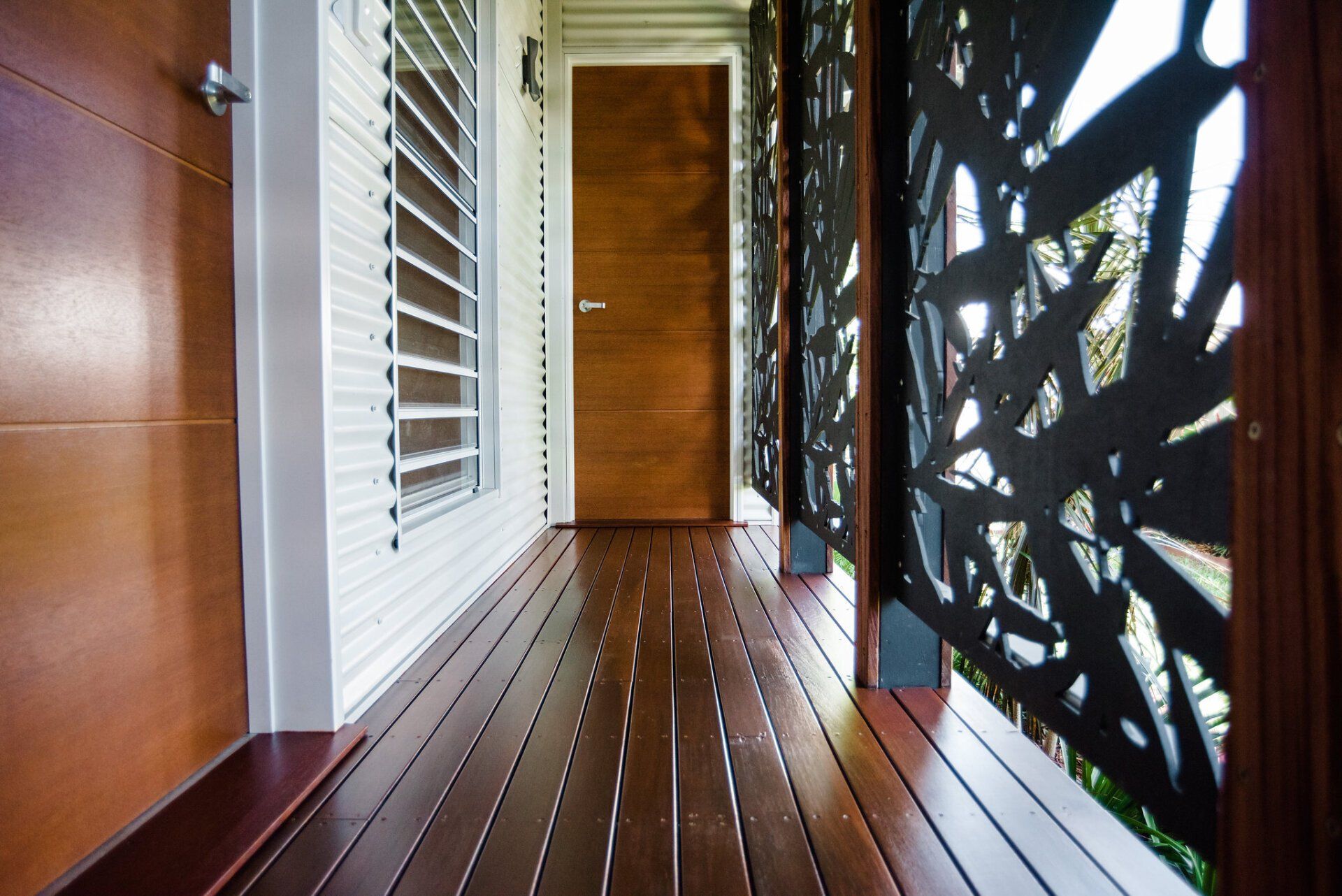 A hallway with a wooden floor and a door — Attention to Detail Cleaning Services & Deck Coating Darwin in Casuarina, NT
