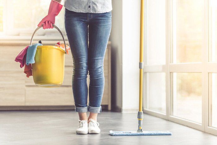 A Woman is Cleaning the Floor with Mop— Attention to Detail Cleaning Services & Deck Coating Darwin in Casuarina, NT