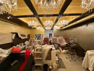 A room with a lot of furniture and chandeliers hanging from the ceiling.