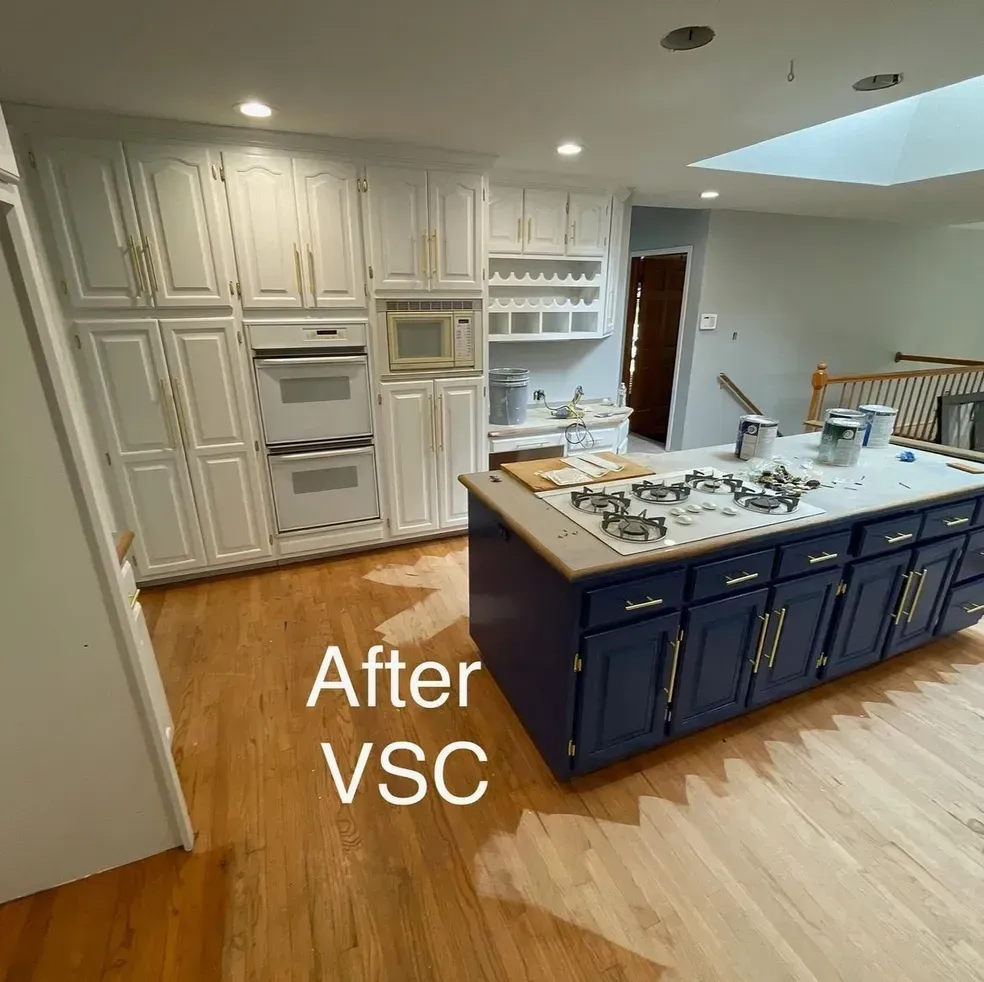 A kitchen with blue cabinets and white cabinets is being painted.