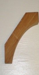 Wooden bracket with a curved edge and a square top and bottom, against a white surface.