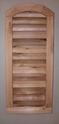 Wooden shutter with a curved top, mounted on a wall.
