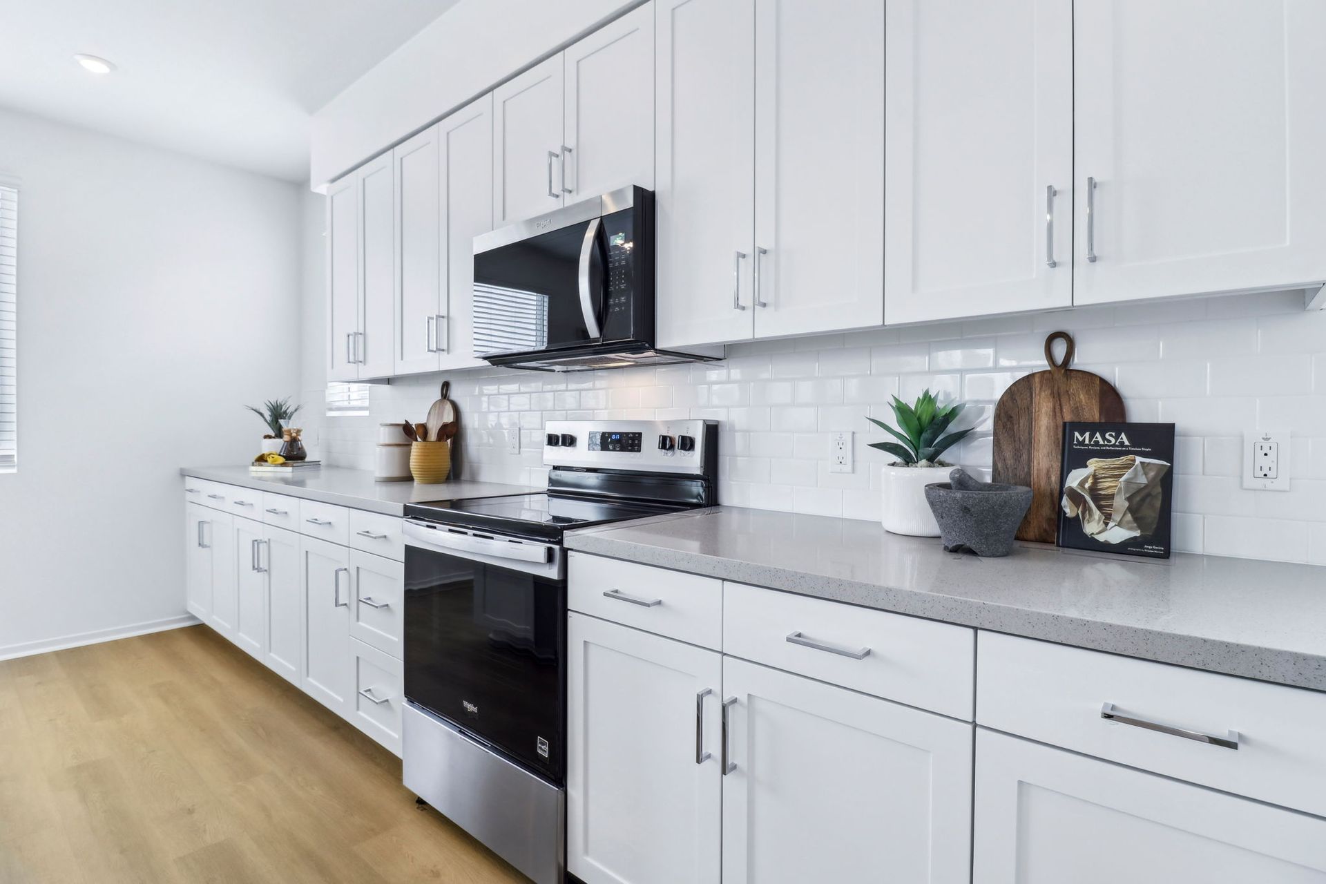 A kitchen with white cabinets and stainless steel appliances.