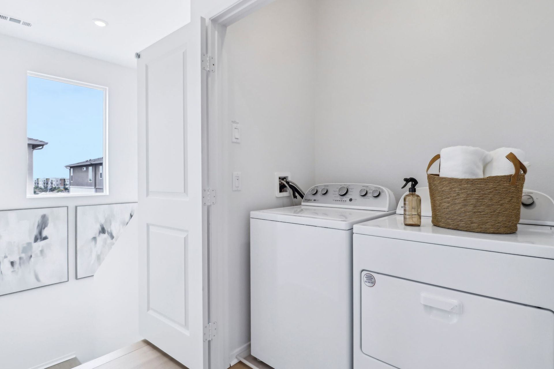 A laundry room with a washer and dryer and a basket of towels.