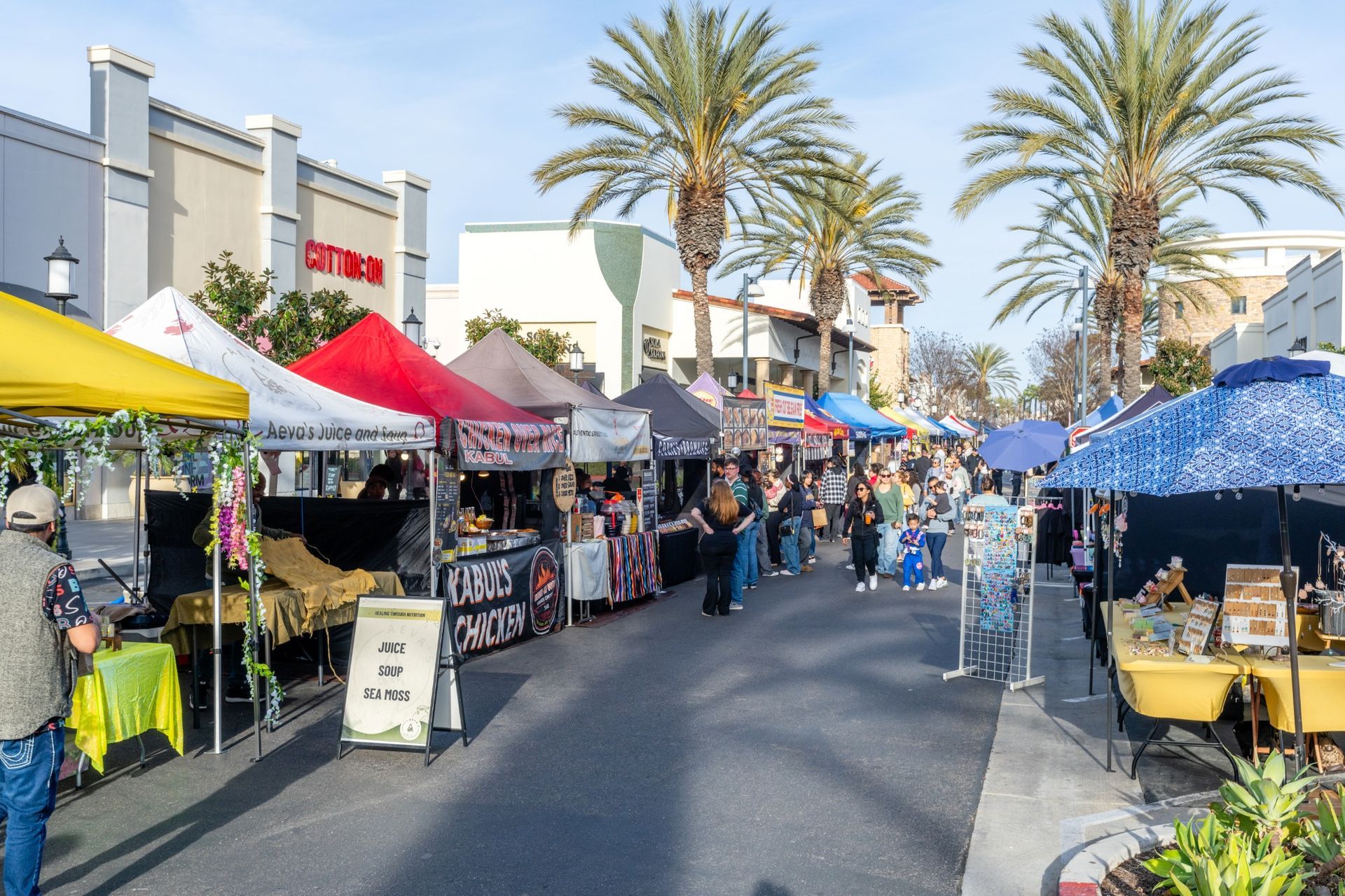 A street filled with lots of tents and people at a market.