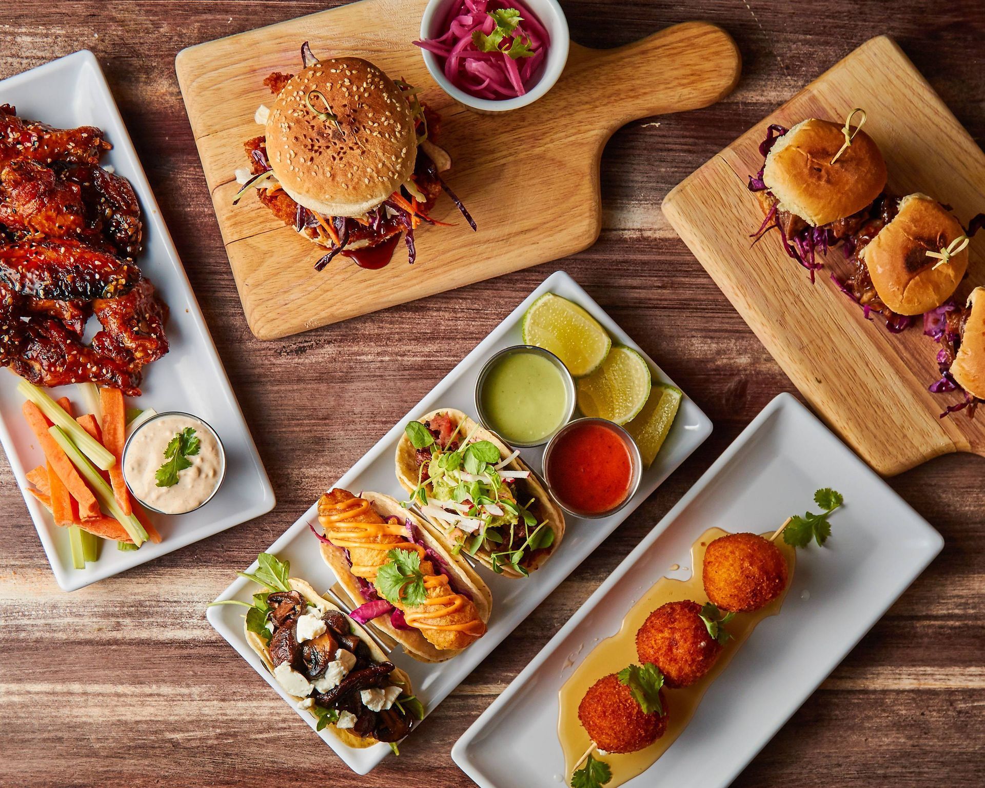 A variety of plates of food on a wooden table