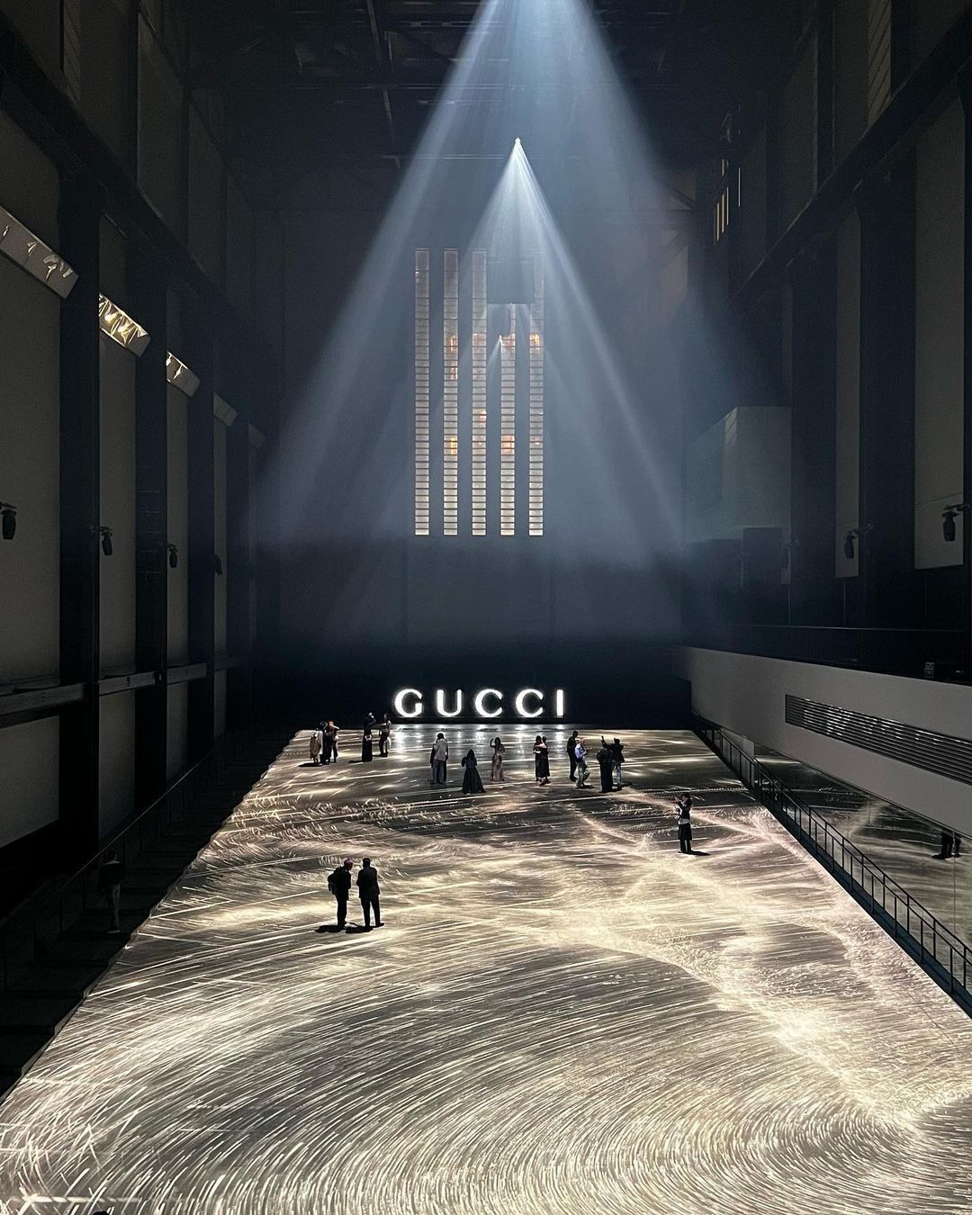 A dramatic wide-angle view of the Gucci Cruise 2025 fashion show setup at Tate Modern, London. 