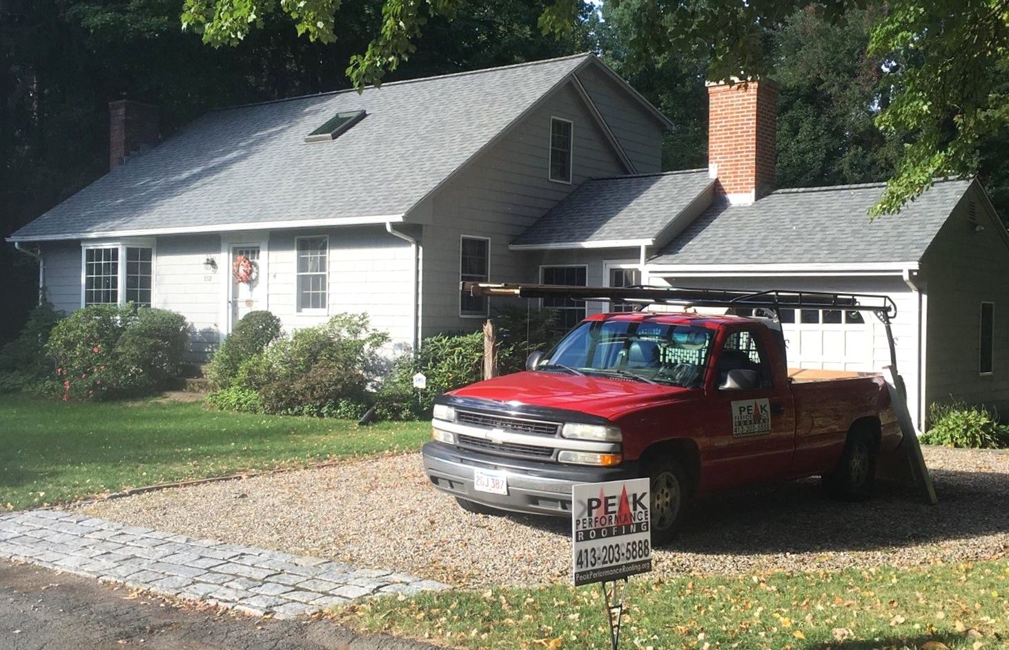 A red truck is parked in front of a house