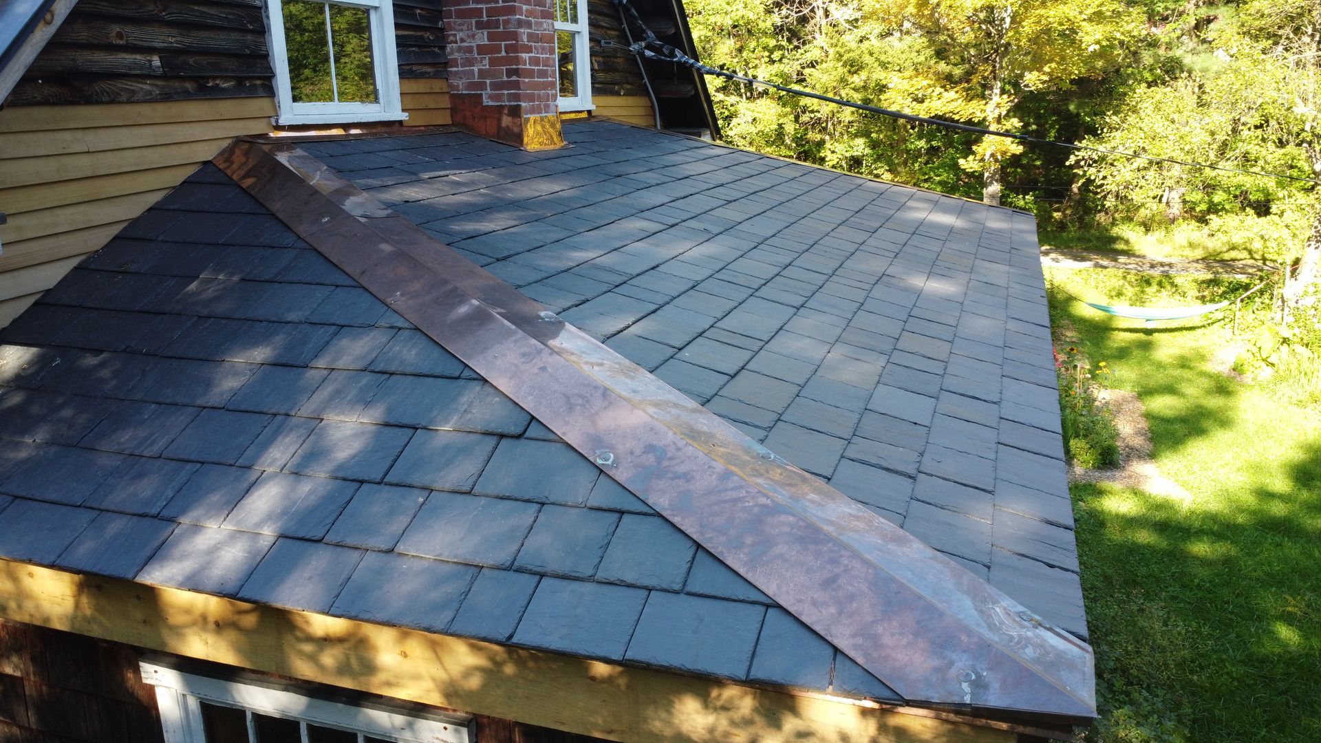A roof with a copper trim is being installed on a house.