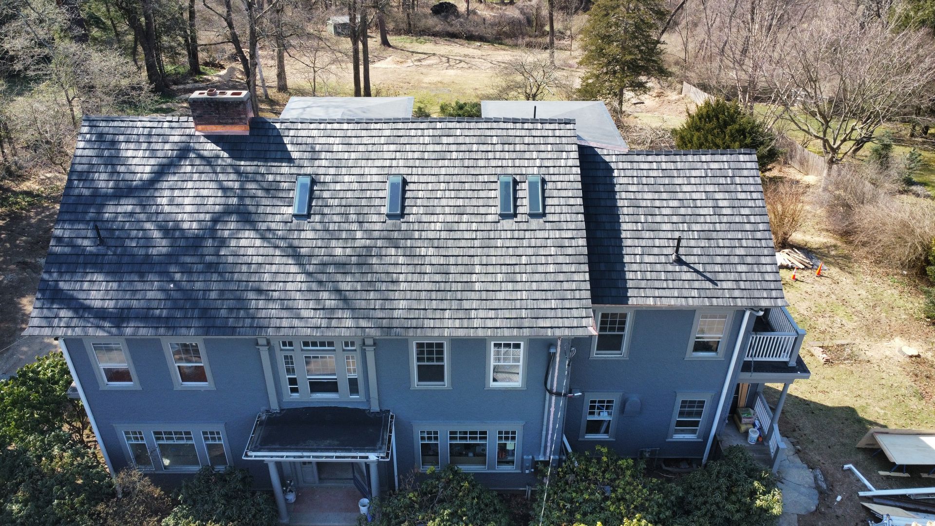 An aerial view of a large house with a slate roof. An aerial view of a large house with a slate roof.