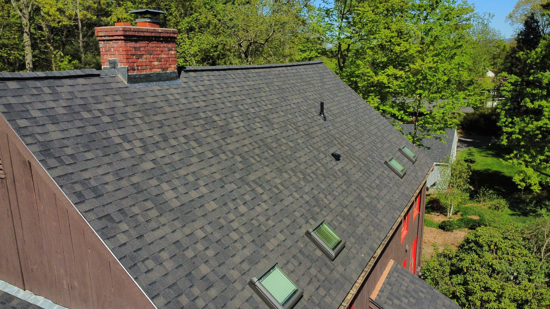 An aerial view of a roof with skylights and a chimney.