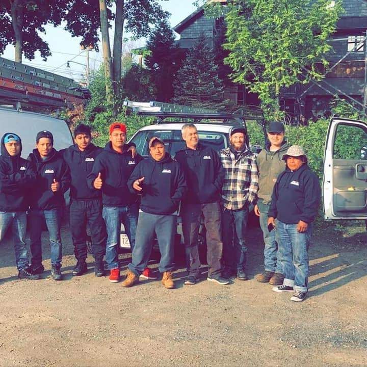 A group of men is posing for a picture in front of a truck.