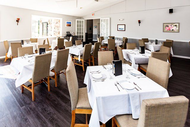 A large dining room with tables and chairs set for a meal.