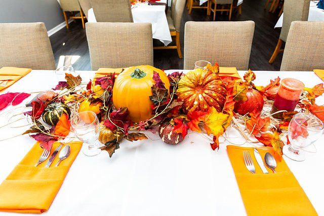 A table decorated for thanksgiving with pumpkins and leaves