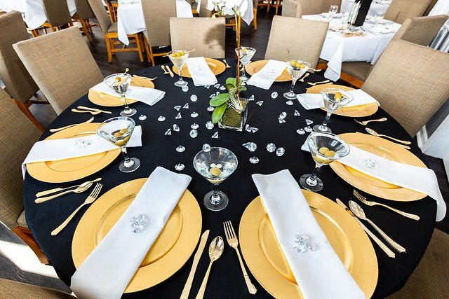 A table set for a wedding reception with gold plates and white napkins