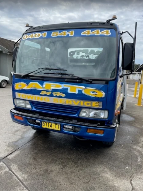 A man is loading a damaged van onto a tow truck.