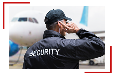 A security guard is standing in front of an airplane.