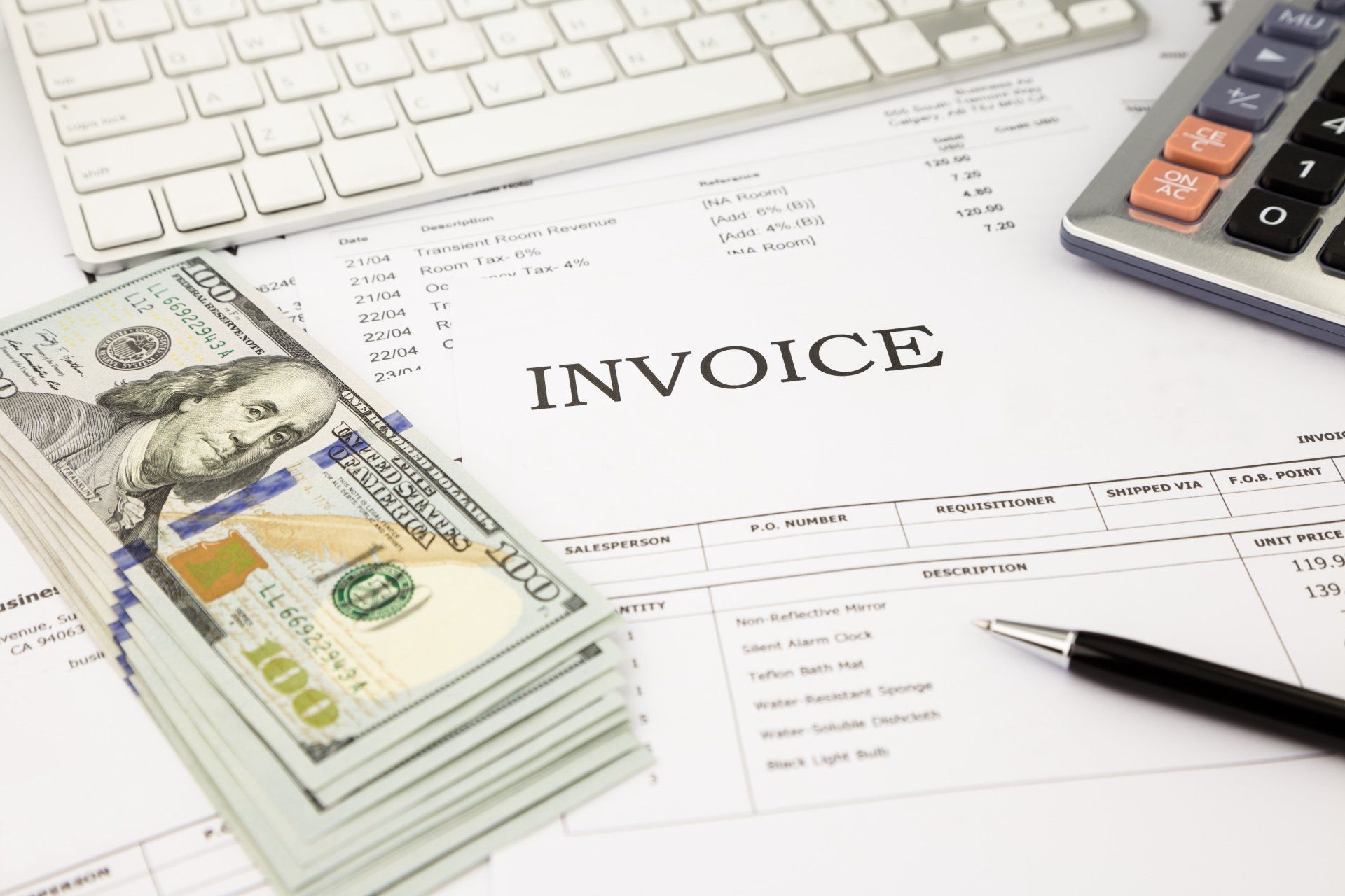 A stack of money is sitting on top of an invoice.