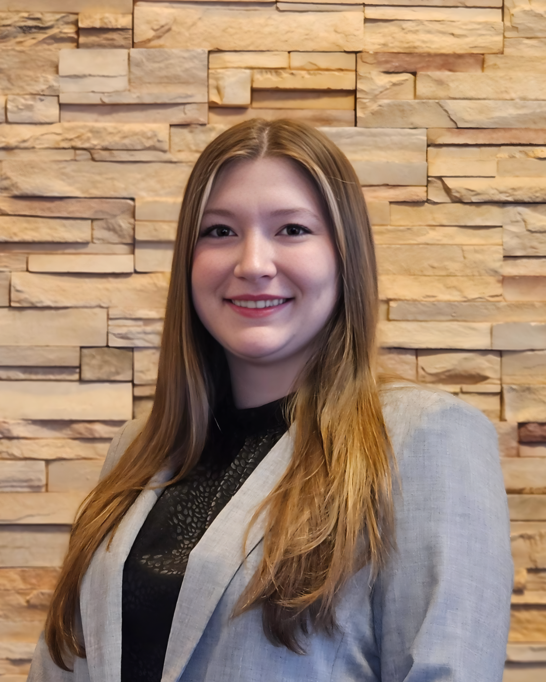 Emily smiling in gray suit jacket