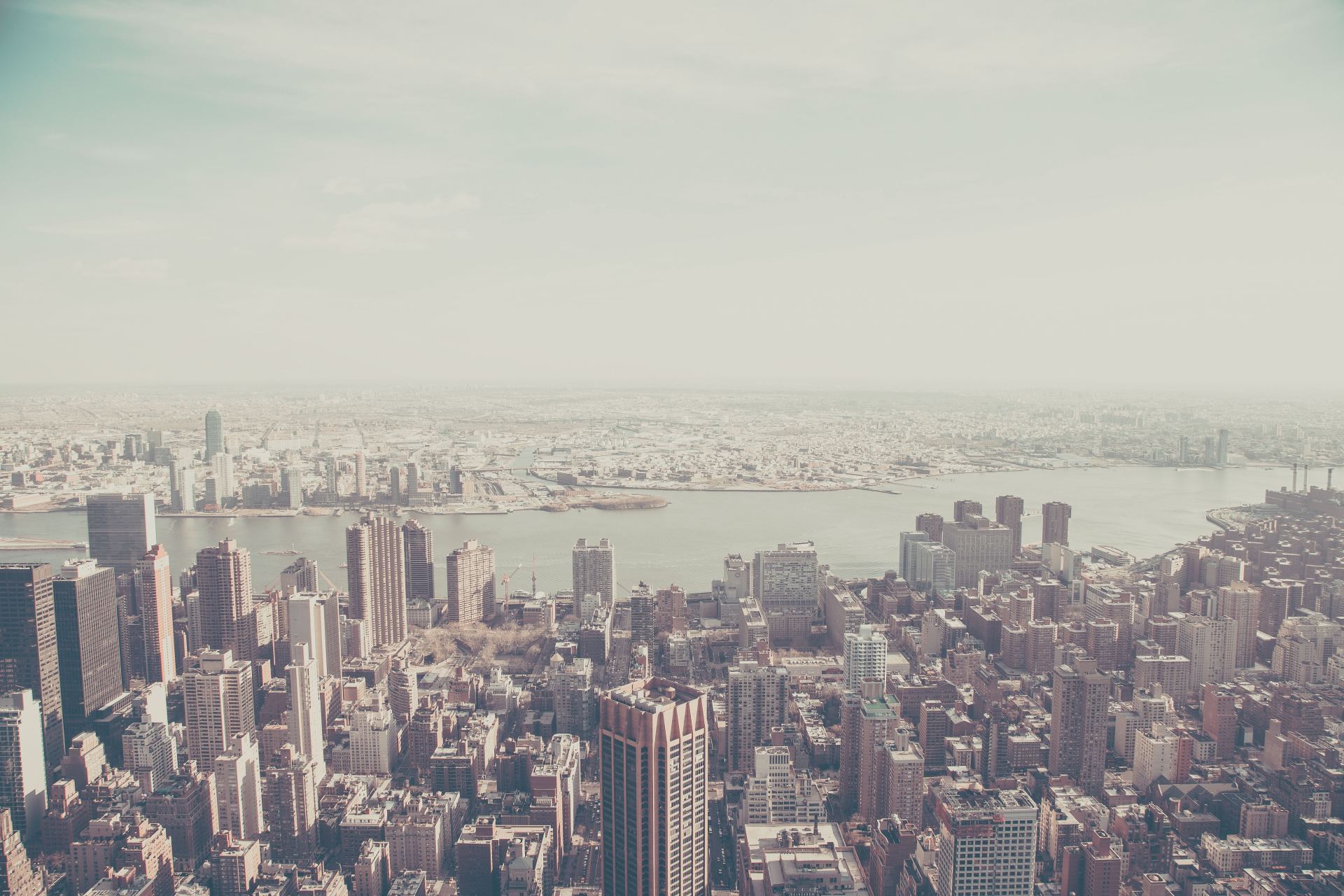 An aerial view of a city with a river in the background.
