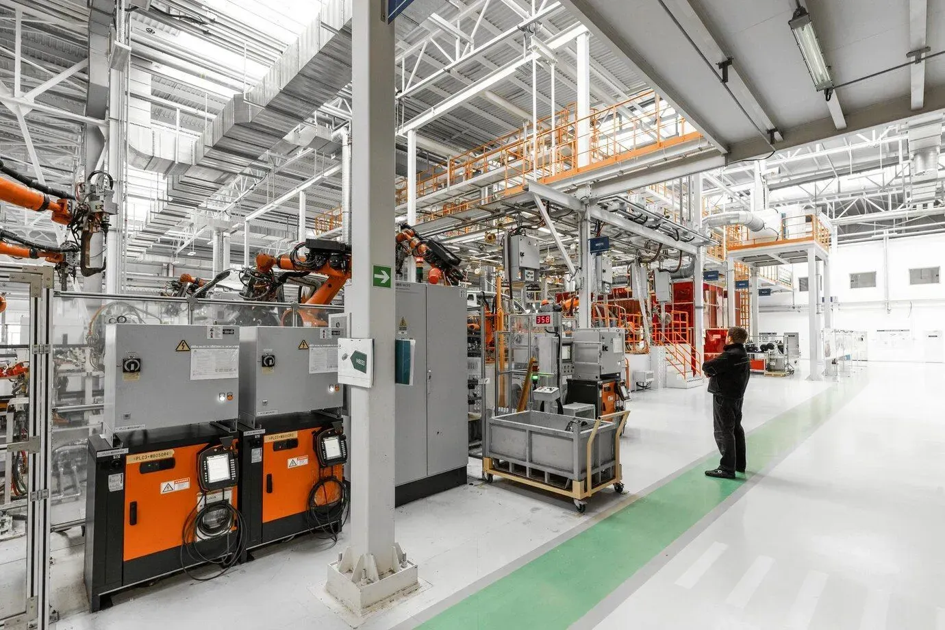 A man is standing in a factory looking at a machine in Los Angeles, CA