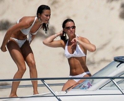 Two women in bikinis are standing on a boat