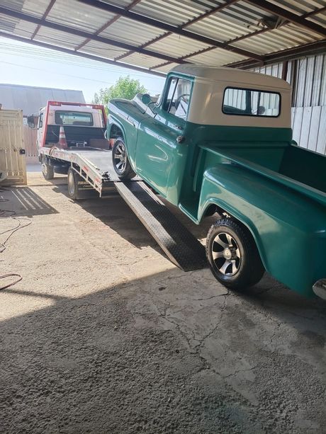 grua lleva una camioneta verde