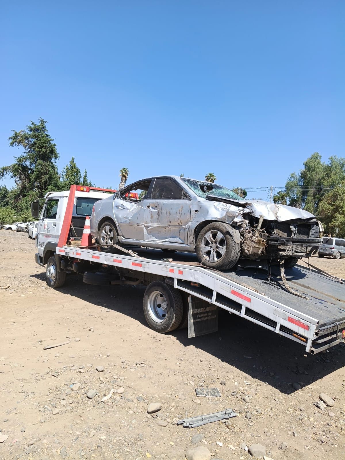 grua por carretera lleva un auto gris