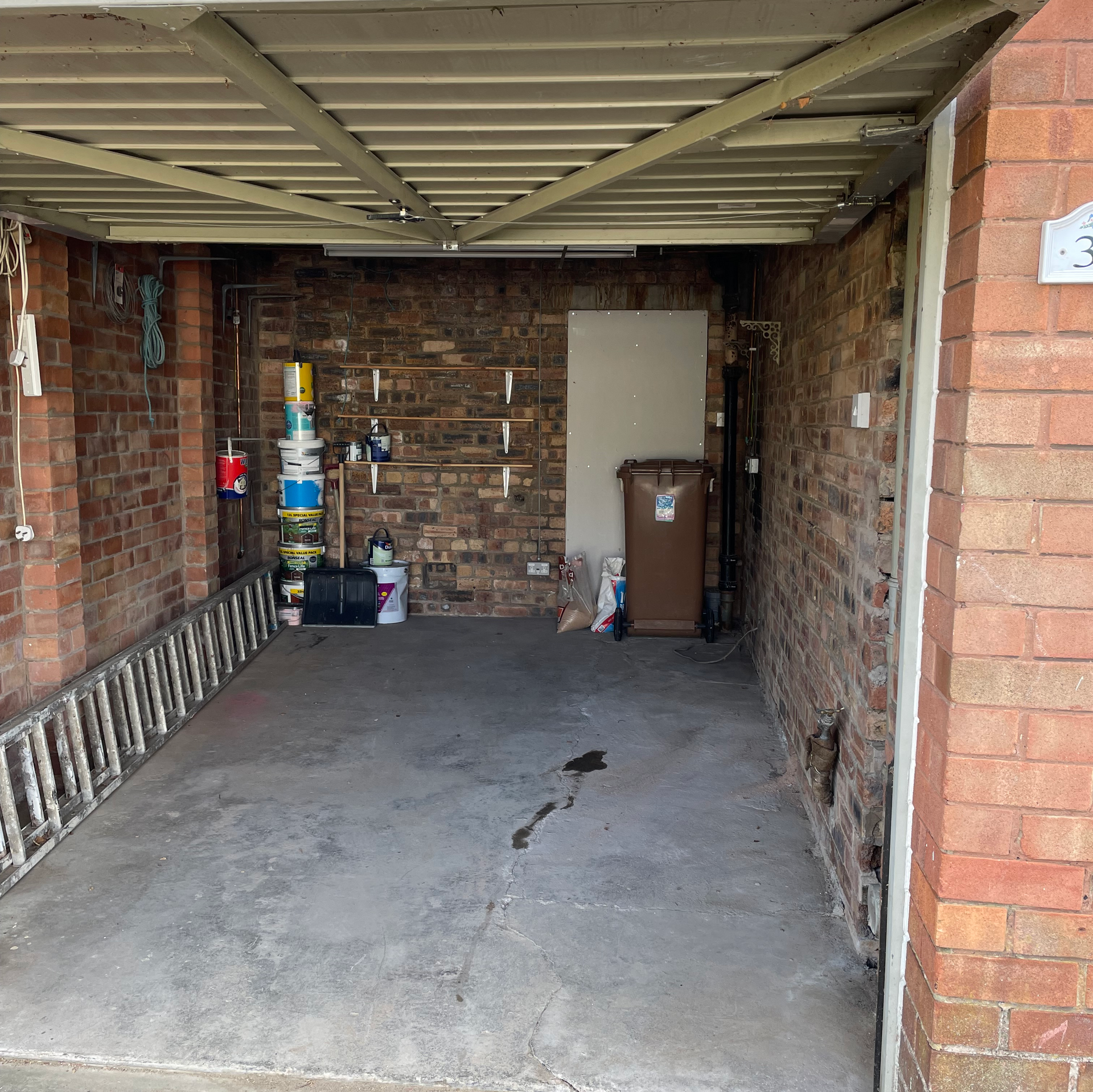 The same garage as in the first picture, now clean and empty apart from a ladder and a few tins of paint.