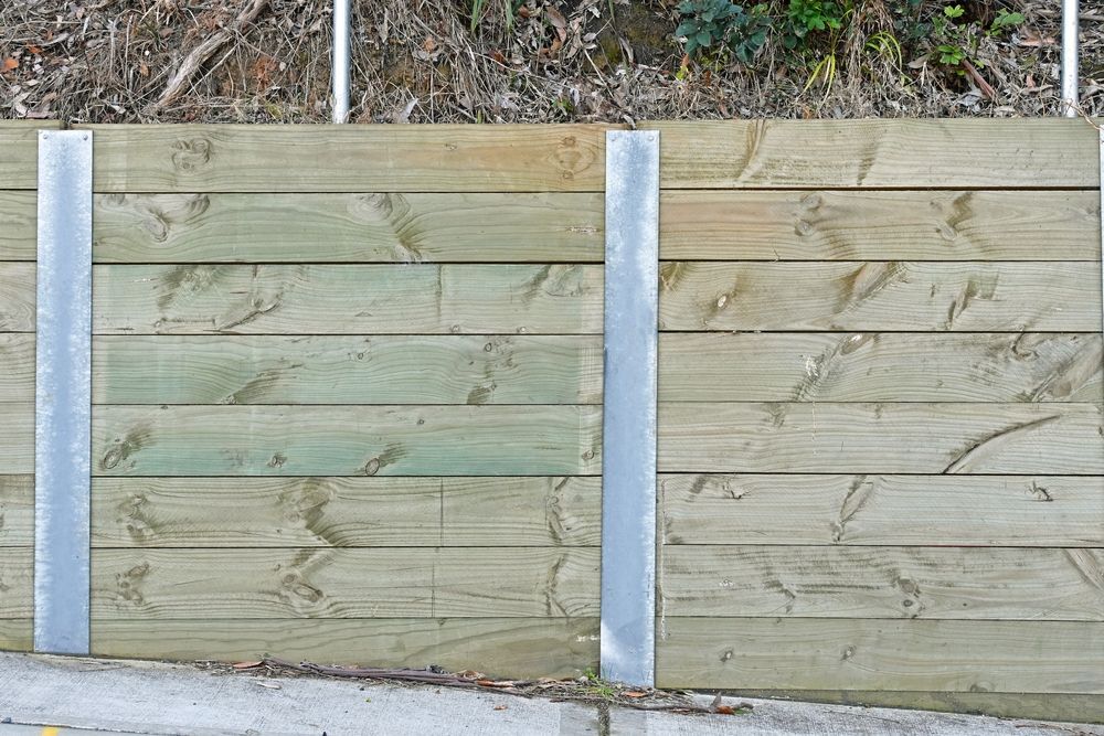 A Close Up of a Wooden Fence With Metal Posts — Marshall Notaras Hardwoods Pty Ltd In Sydney, NSW
