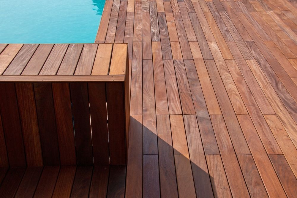 A Wooden Deck Next to a Swimming Pool — Marshall Notaras Hardwoods Pty Ltd In Coffs Harbour, NSW