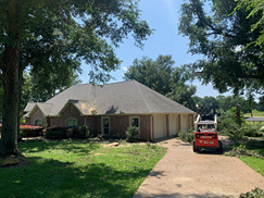 A house with a tractor parked in front of it.