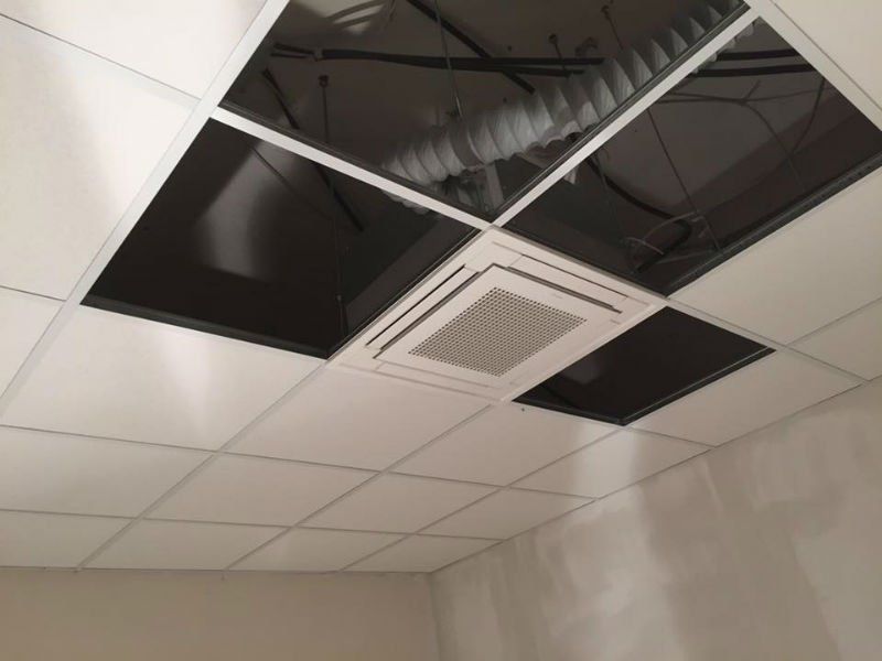 dei condotti d’aria visibili attraverso un soffitto a pannelli non ancora finito