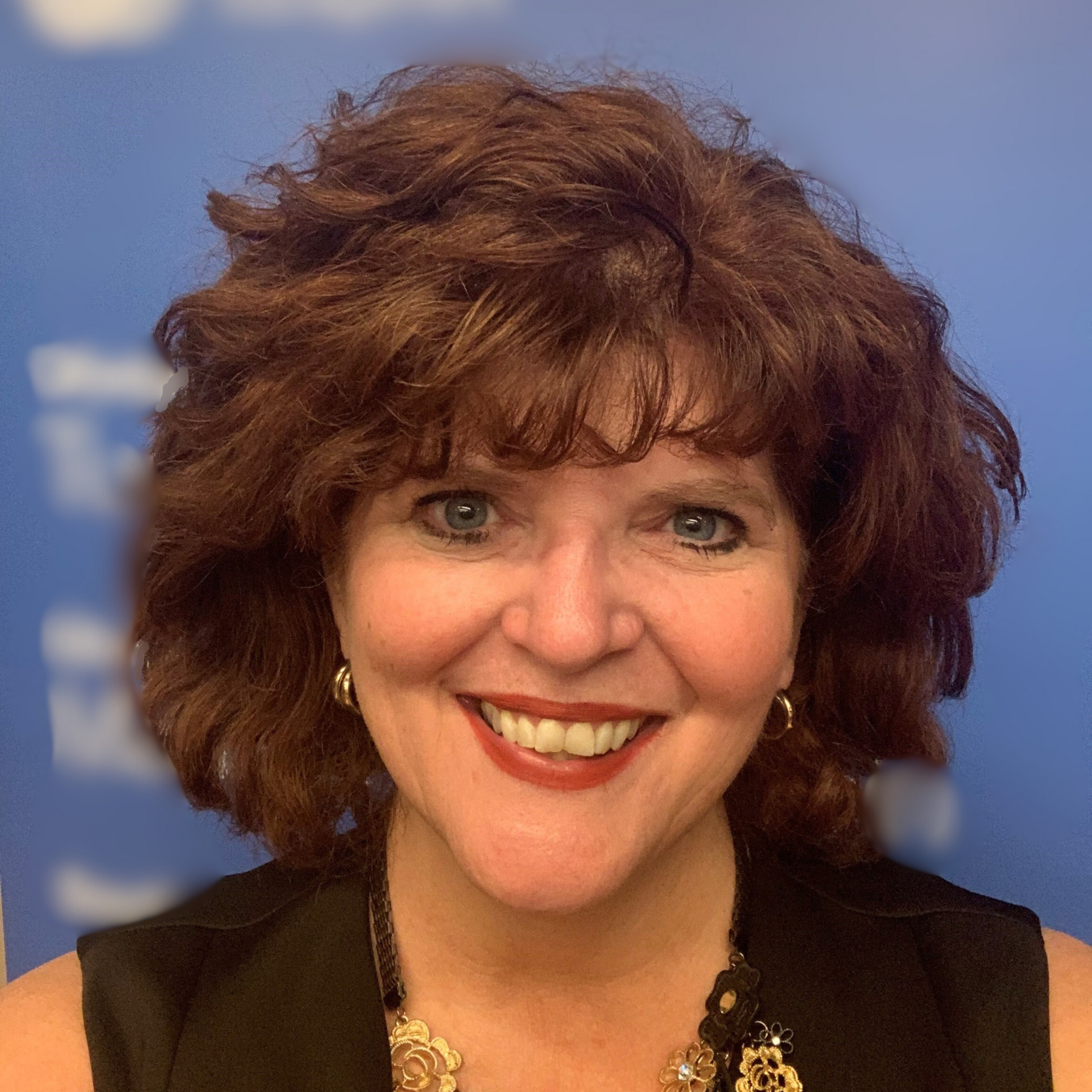 A woman in a black shirt is smiling for the camera