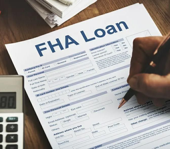 A person is filling out a form that says fha loan