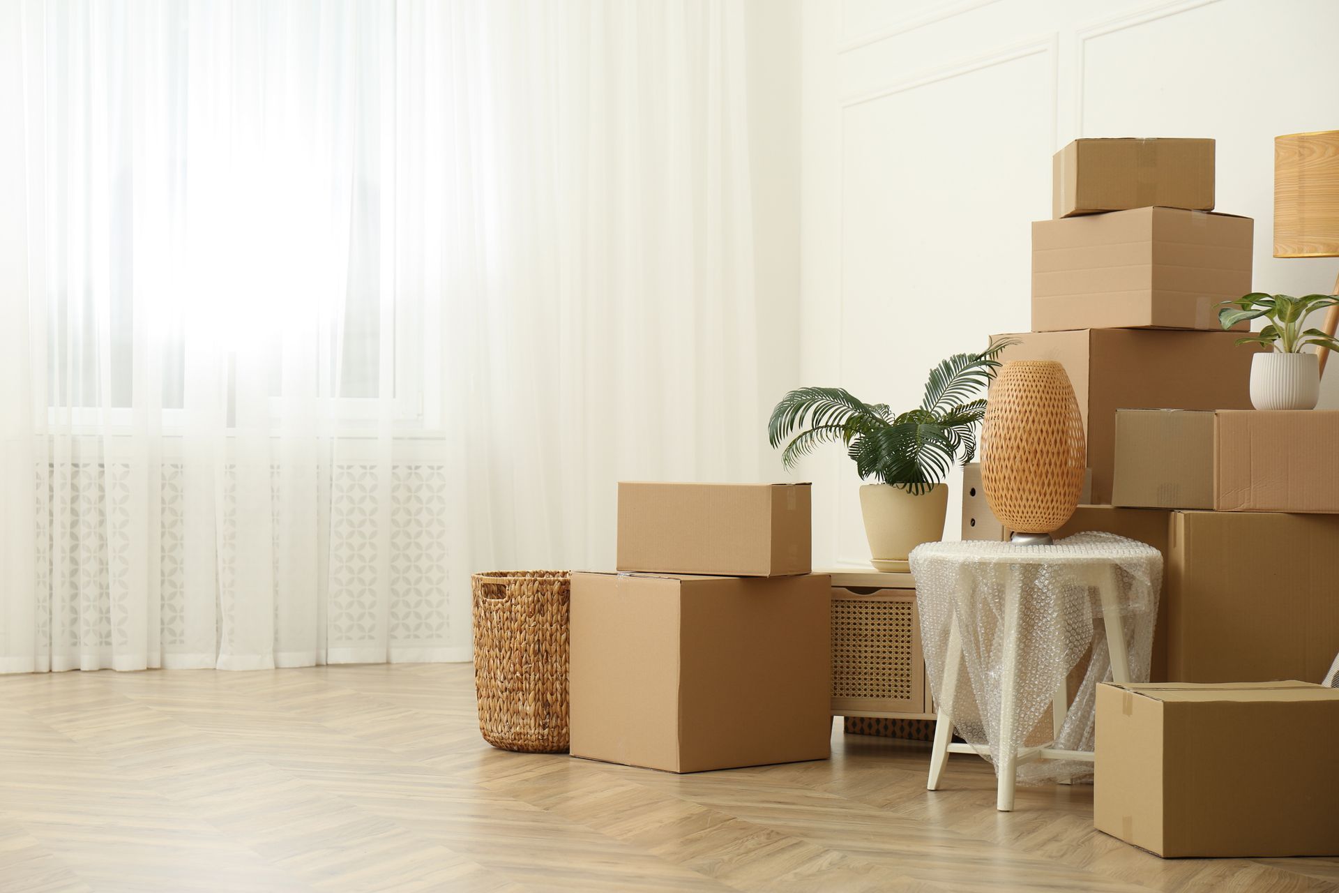 Cardboard boxes stacked in a bright room, ready for moving.
