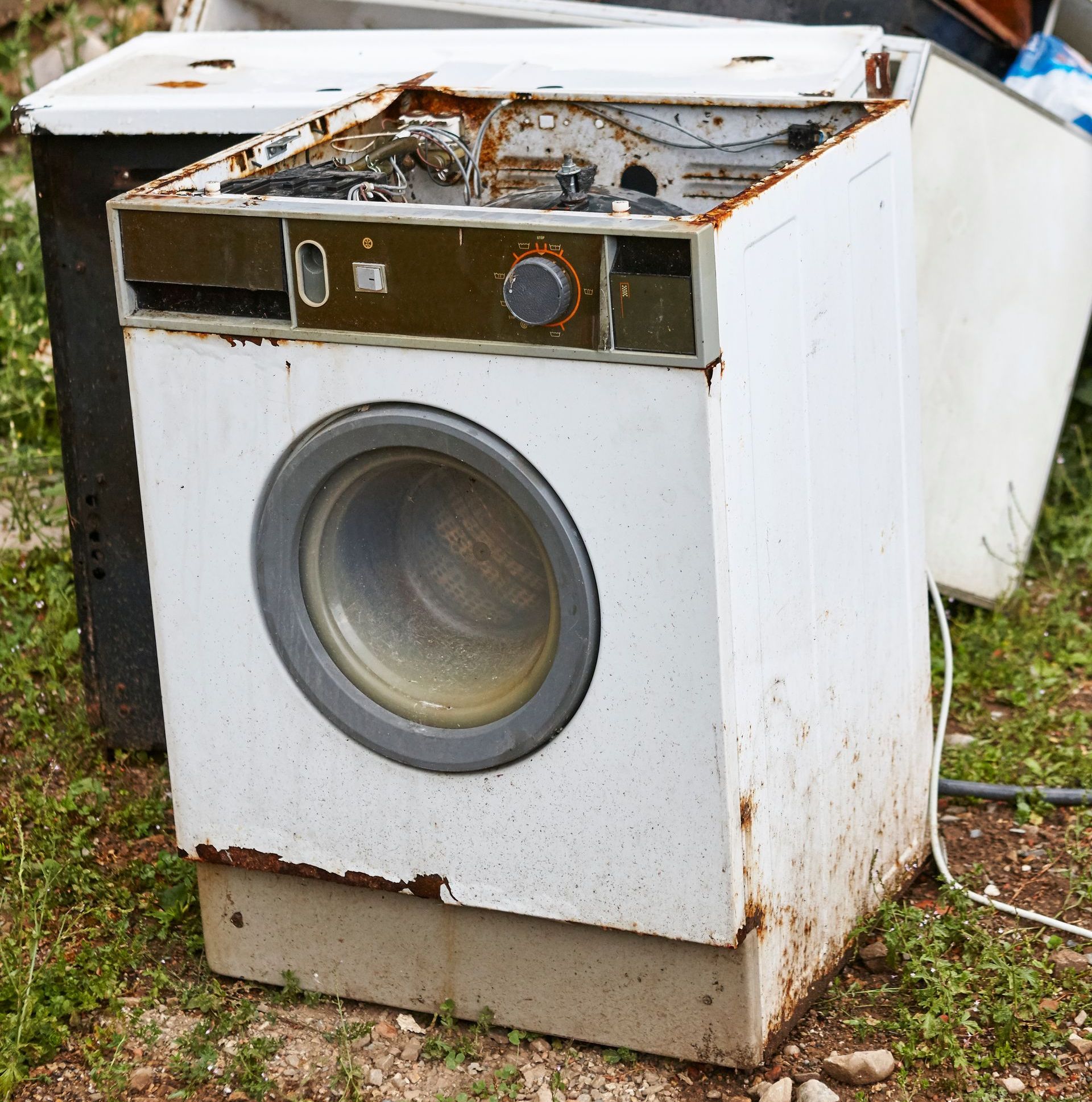 a white washing machine is sitting in the grass