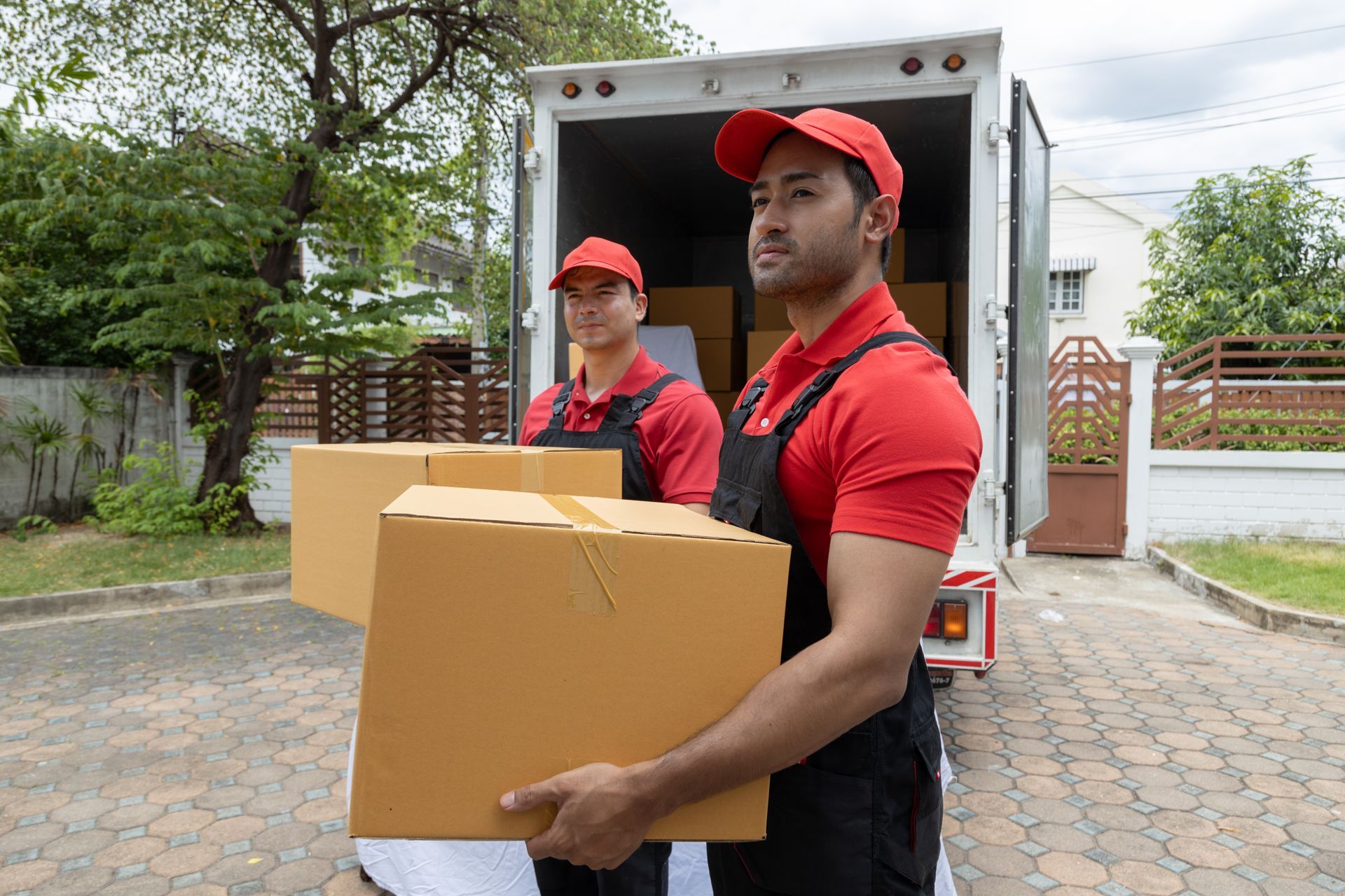 two men are carrying boxes out of a truck .
