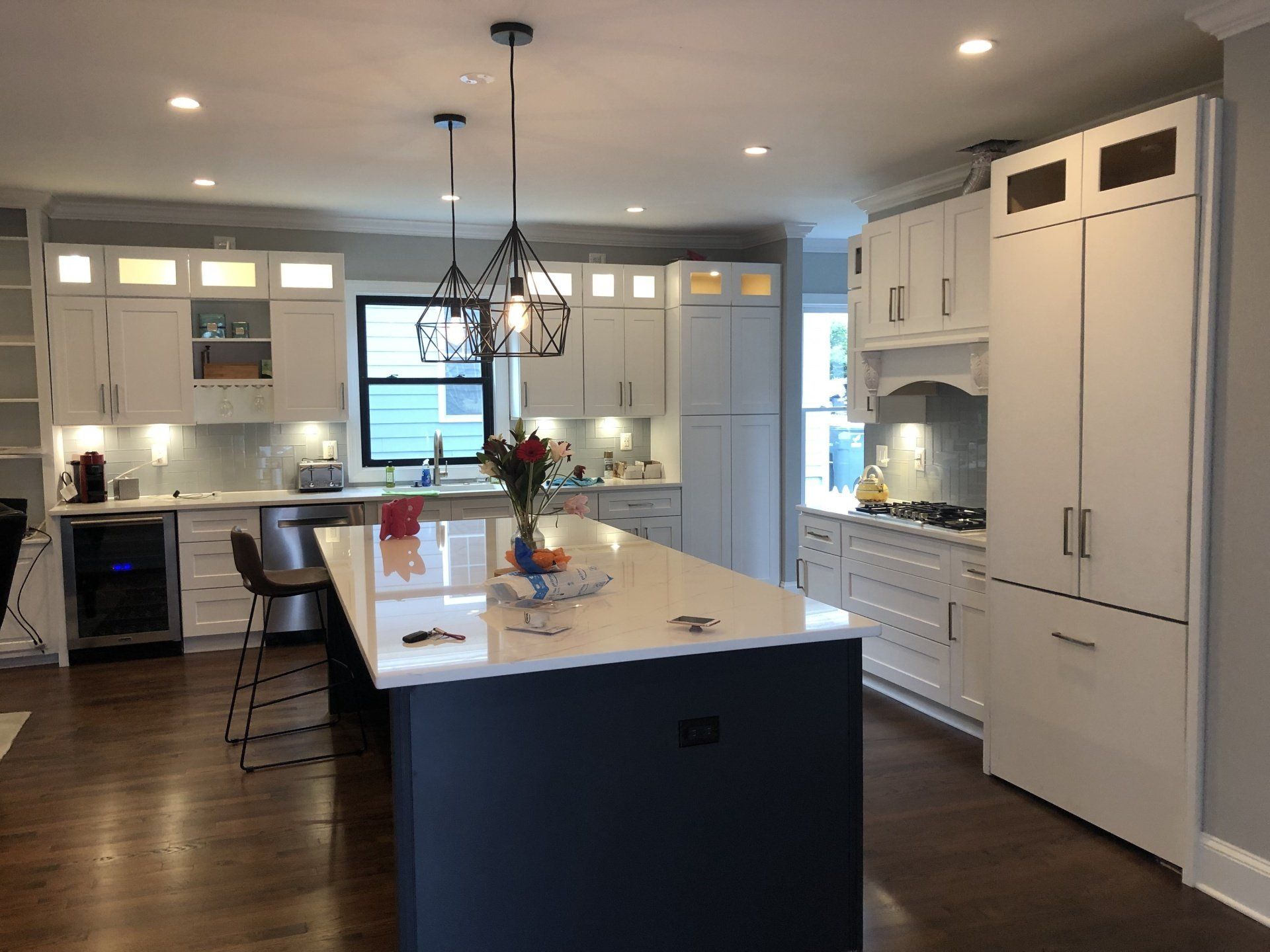 a kitchen with white cabinets and a large island in the middle .