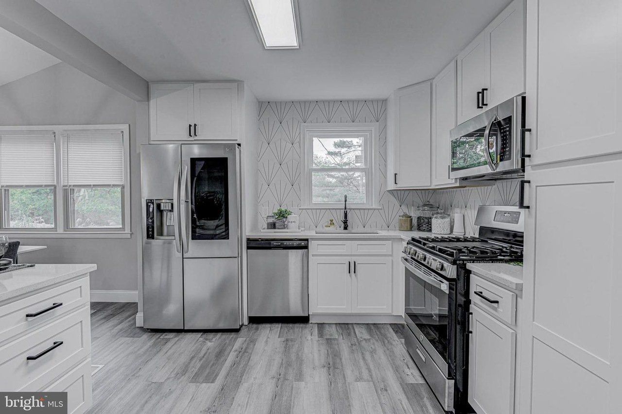 a kitchen with stainless steel appliances and white cabinets .