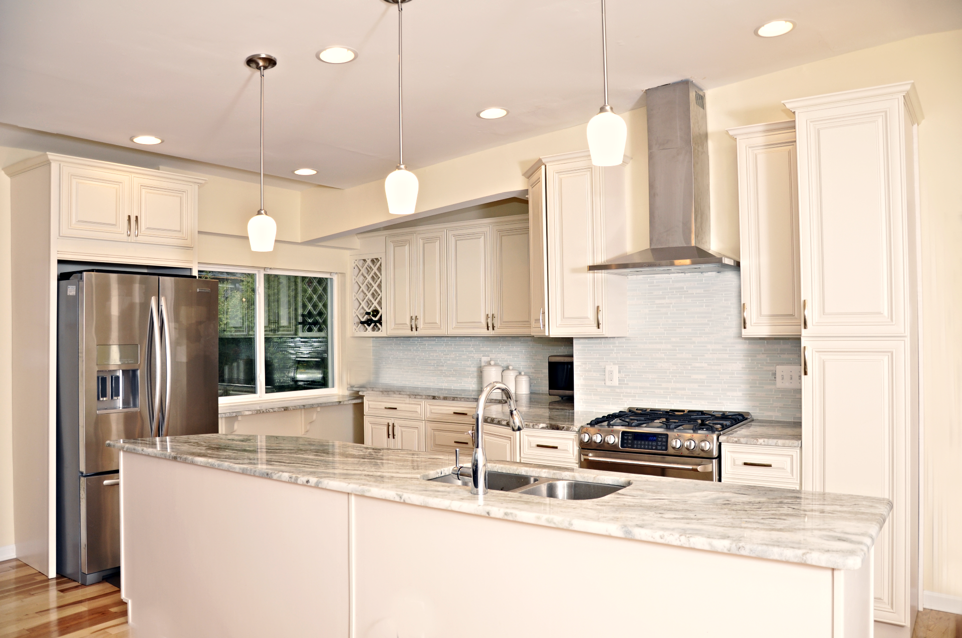 a kitchen with white cabinets and stainless steel appliances .