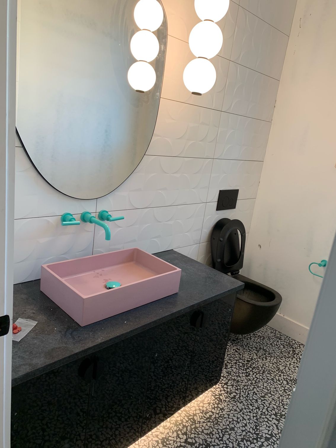 a bathroom with a pink sink , mirror and toilet .