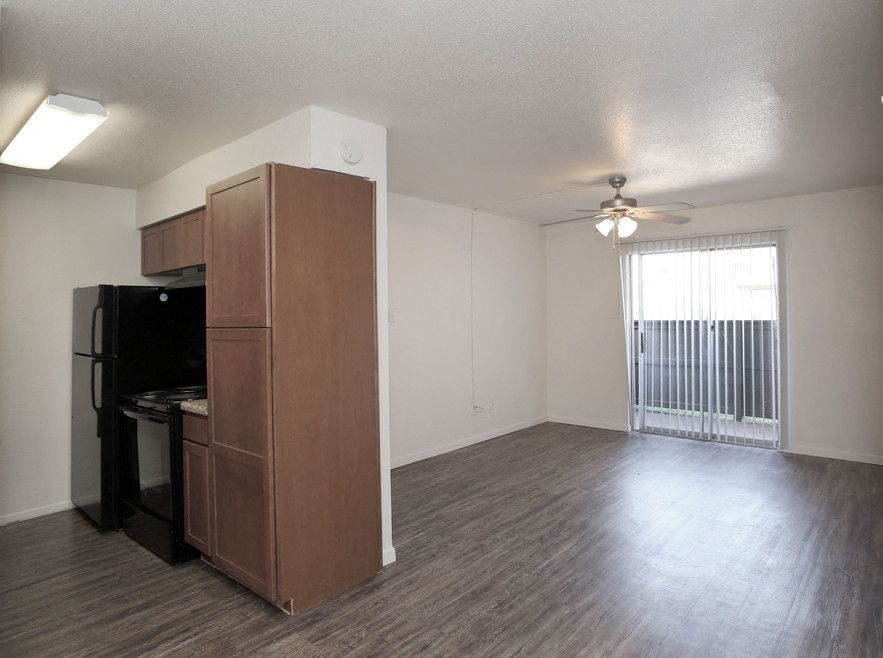 Open-concept apartment living area with a kitchen and a sliding glass door to a balcony.