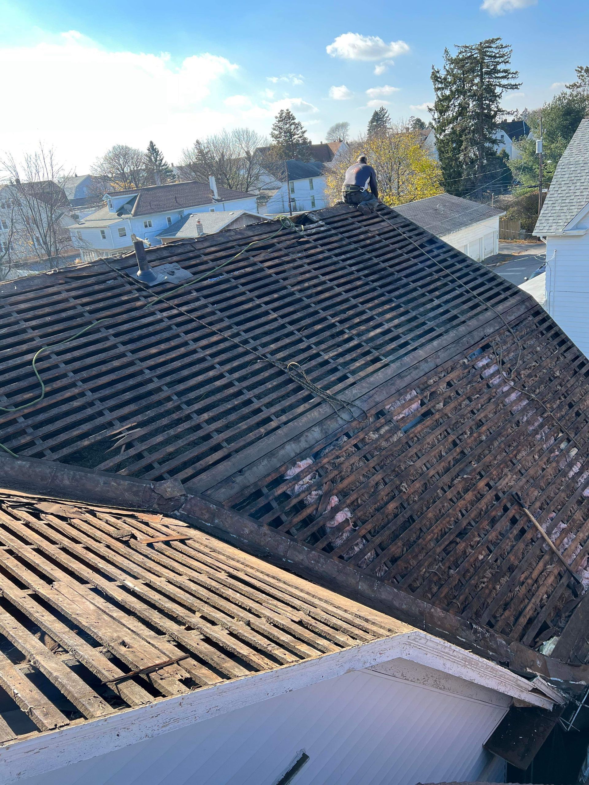 A man is standing on the roof of a house