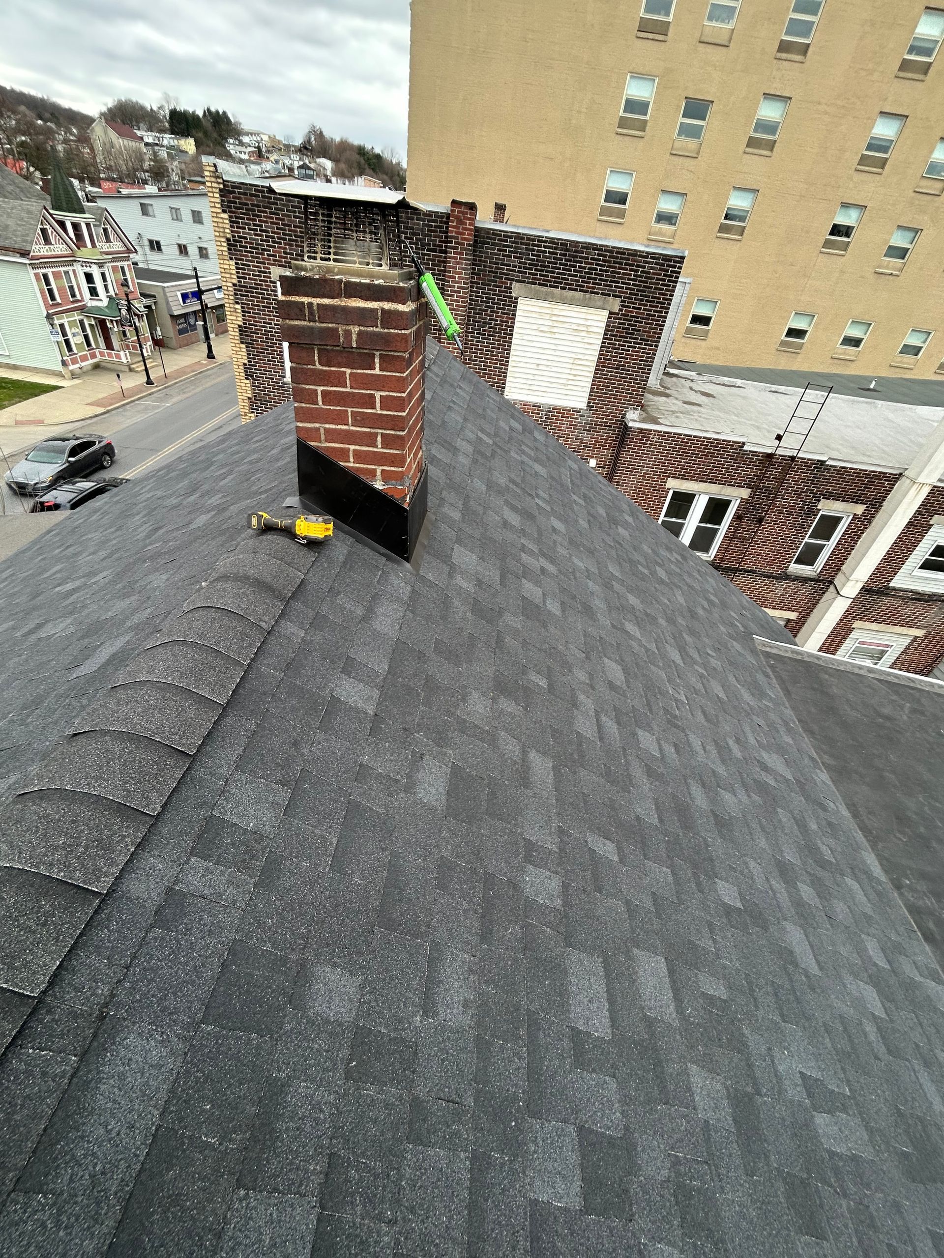 A chimney is sitting on top of a roof next to a building