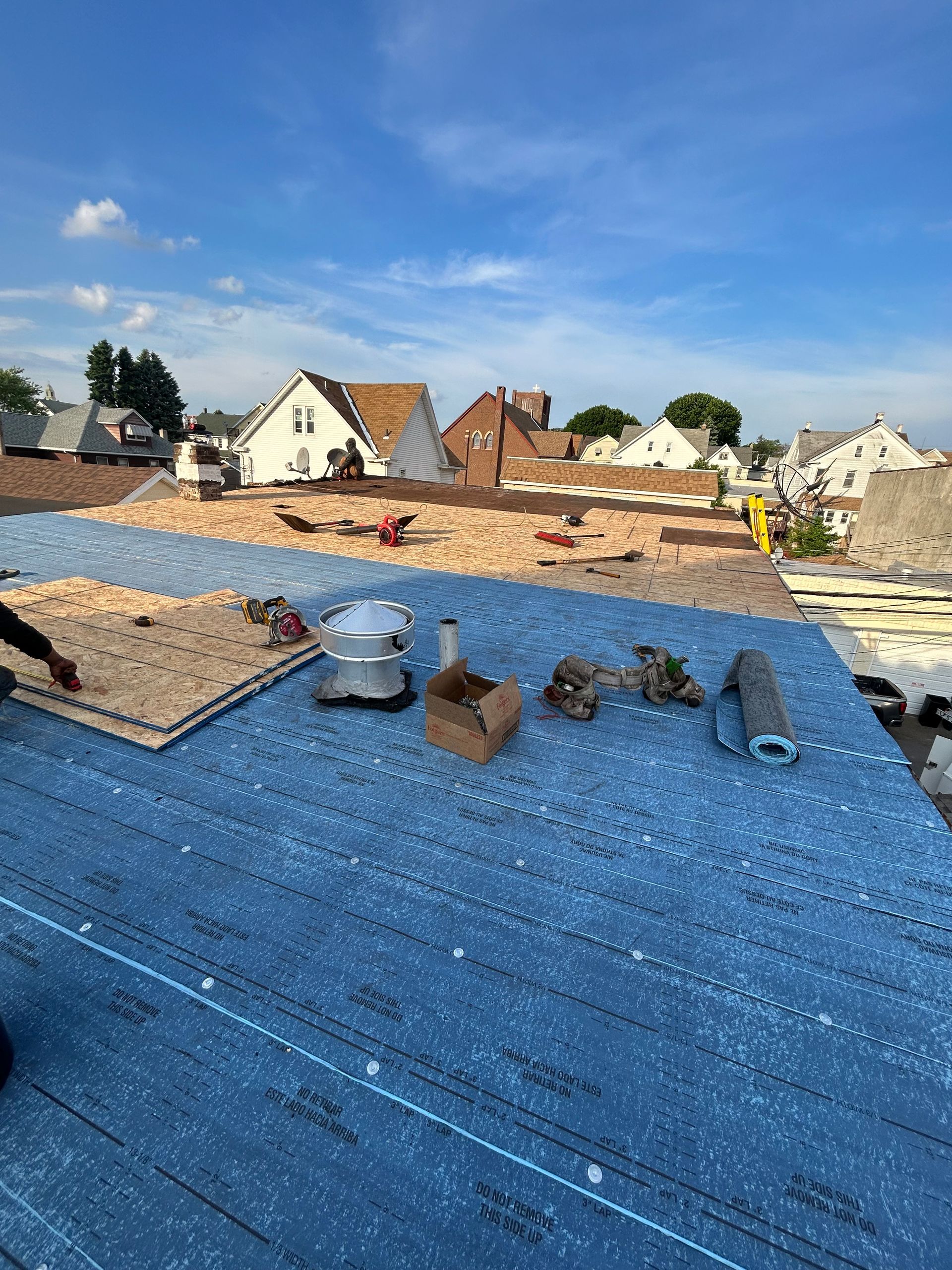 A person is working on a roof in a city