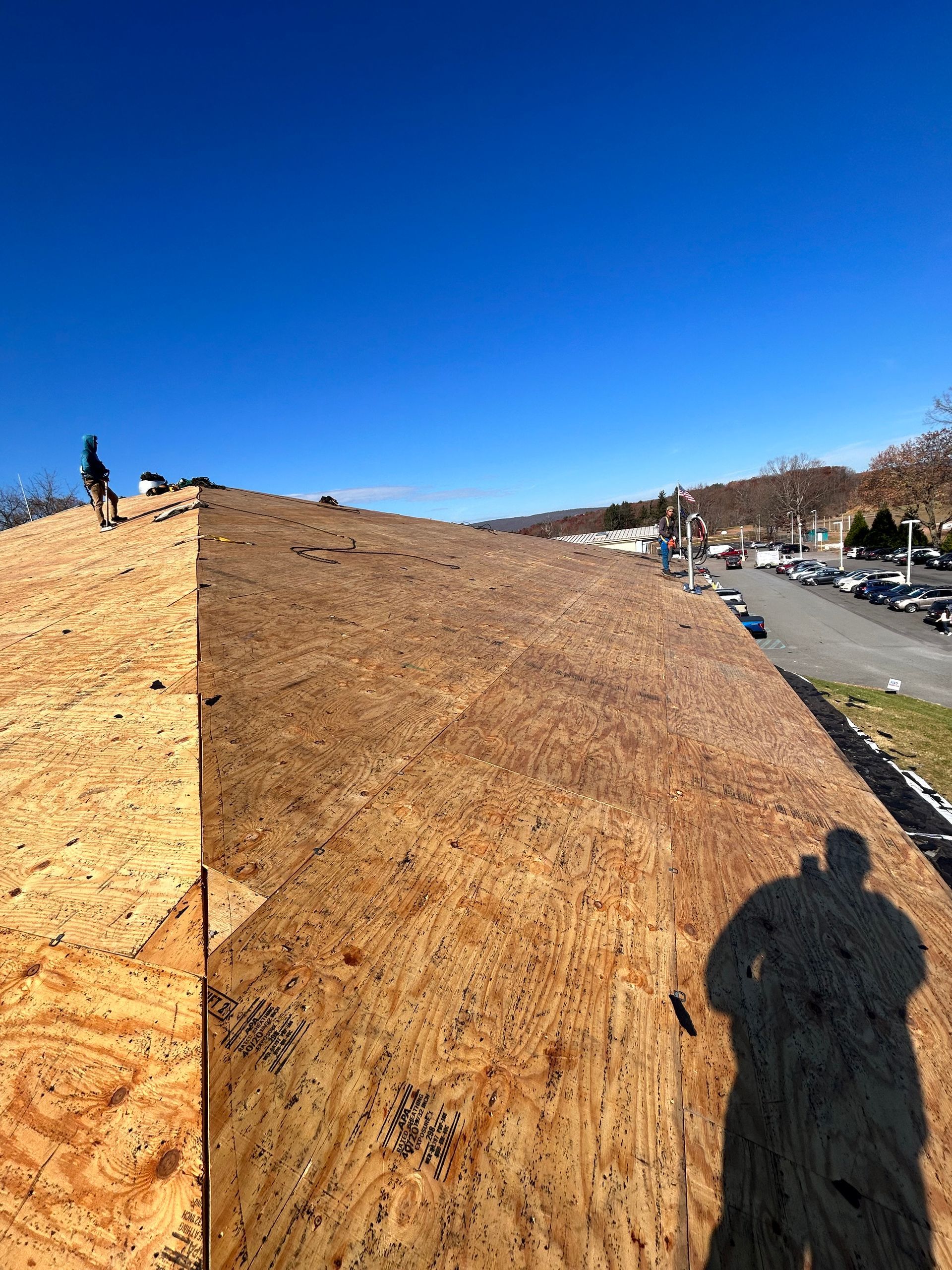 A man is standing on top of a wooden roof