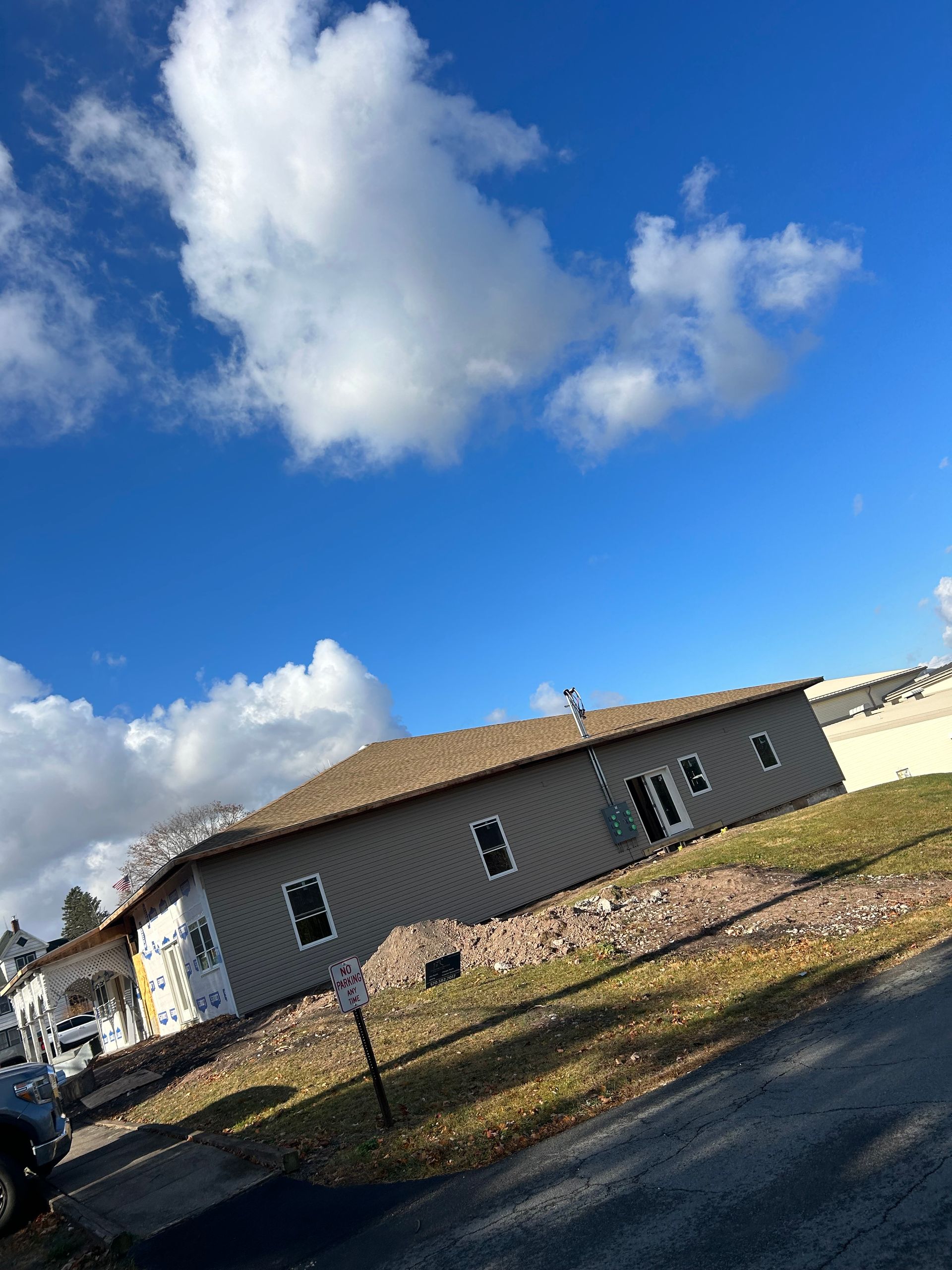 A house under construction with a blue sky and clouds behind it